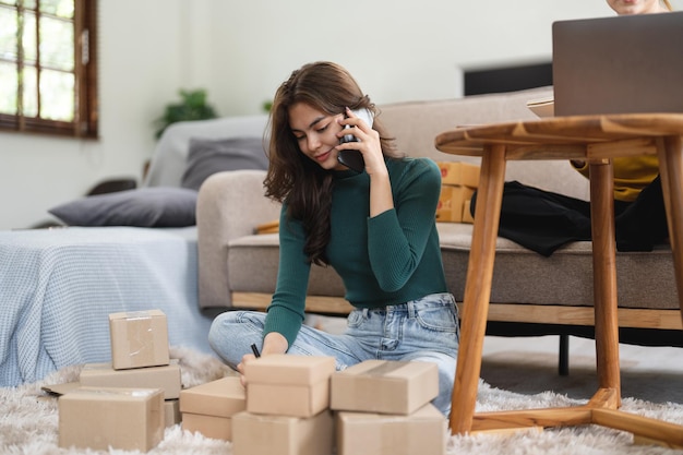 Young business woman working online ecommerce shopping at her shop Young woman seller prepare parcel box of product for deliver to customer Online selling ecommerce