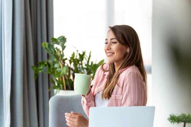 Young business women in the office drinking coffe and looking through a window