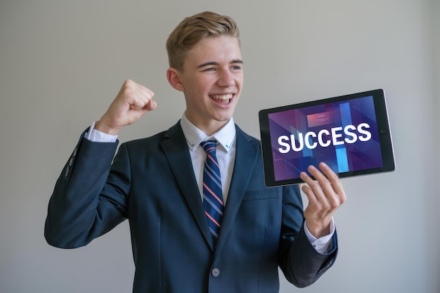 Photo young businessman celebrating success tablet formal attire motivational business success imagery