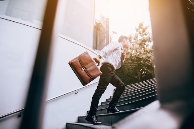 Photo young businessman full of energy and ready to climb any steps to future