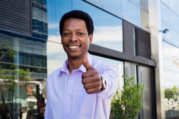 Young businessman giving thumb up.