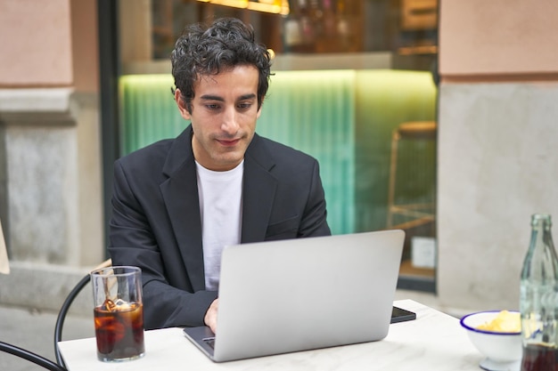 Young businessman hard at work with his laptop focused on achieving his goals