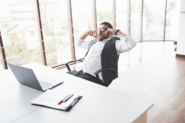 Young businessman having a rest while sitting in chair in the clean room