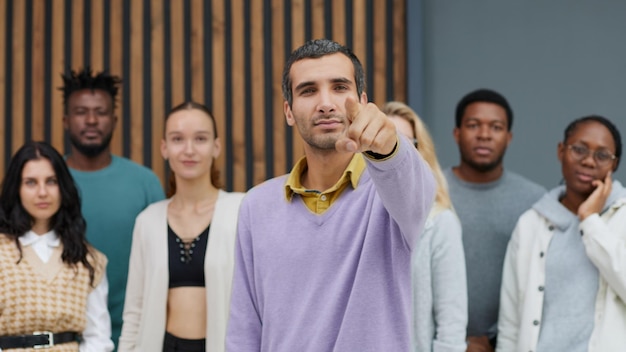 Young businessman points his index finger at the camera