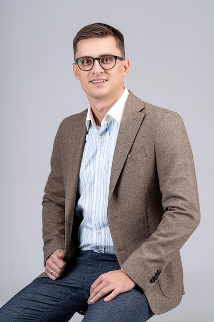 Young businessman portrait. Professional accountant or bookkeeper is looking to the camera. Light gray background.