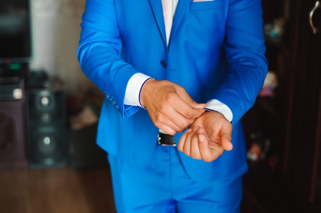 Young businessman puts a suit on before meeting with partners.