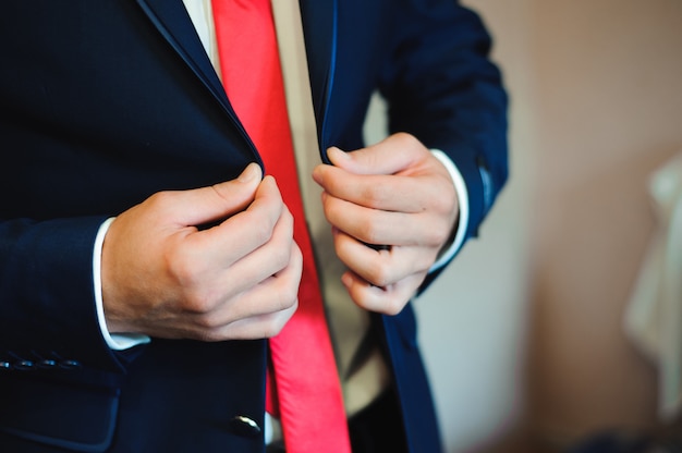 Young businessman puts a suit on before meeting with partners.