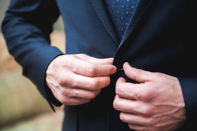 Young businessman puts a suit on before meeting with partners.