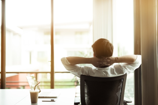 Young businessman relaxing at his desk in office