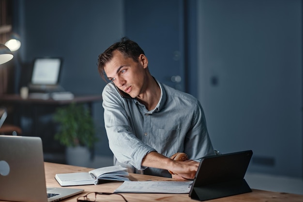 Young businessman snacking on a hamburger while working on a new project