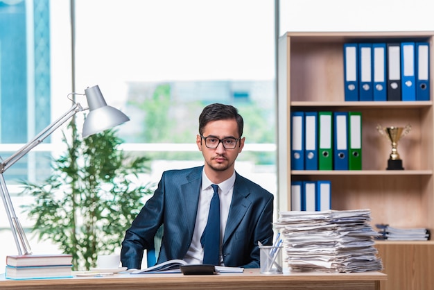 Young businessman in stress with lots of paperwork