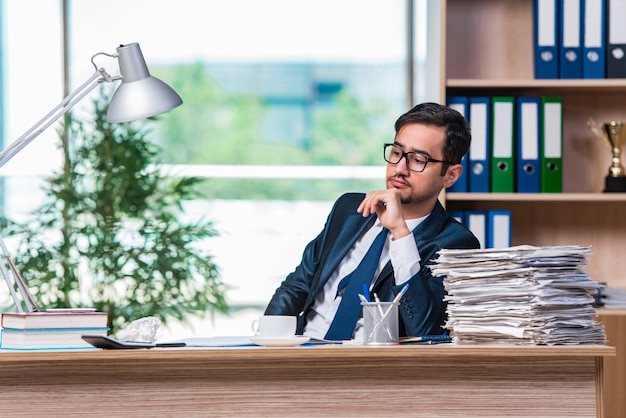 Young businessman in stress with lots of paperwork