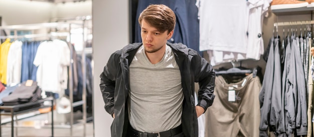 Young businessman try on new jacket in the store