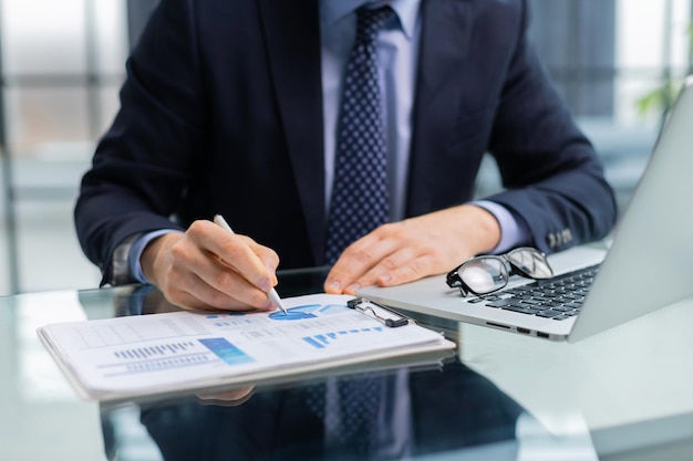 Young businessman typing computer laptop with graph chart for work