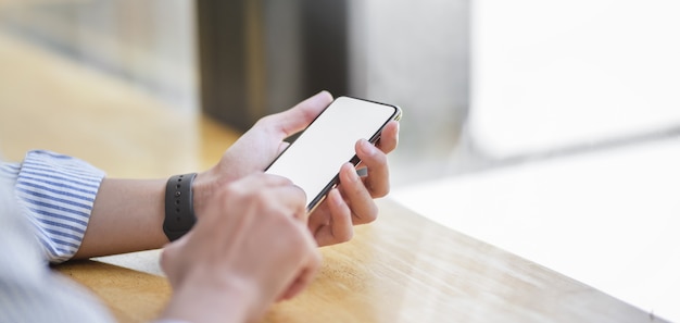 young businessman using blank screen smartphone in comfortable office