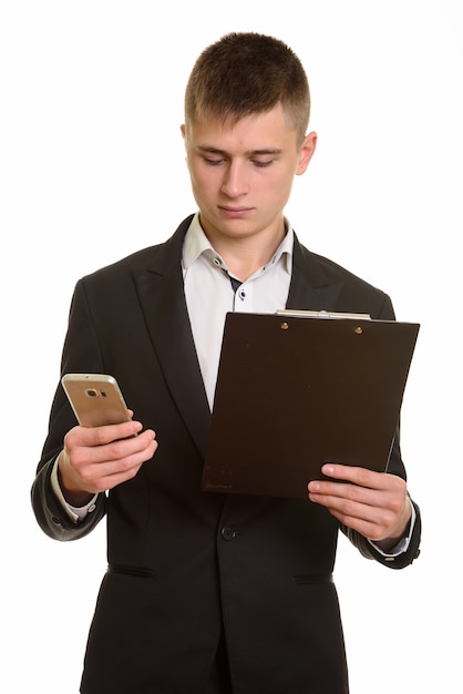 young businessman using mobile phone while holdinh a clipboard