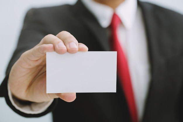 Young businessman who takes out blank business card from the pocket of his shirt business suit, copy space	