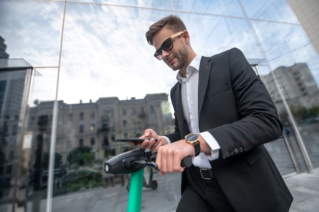 Young businessman with the scooter in the street