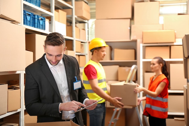 Young businessman with tablet at warehouse