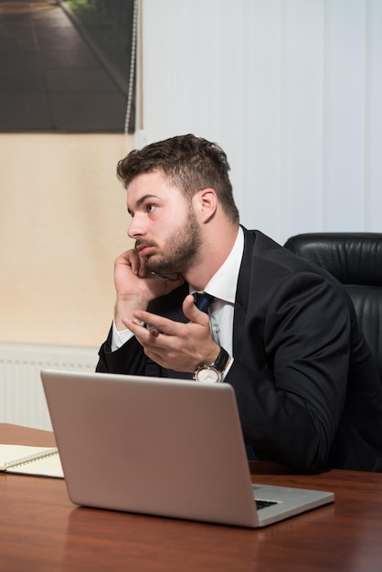 Young Businessman Working In His Office While Talking On The Phone