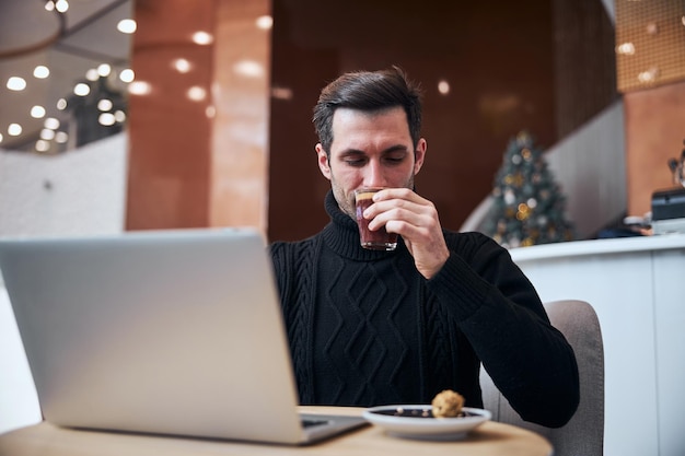 Young businessman working in internet with cup of coffee