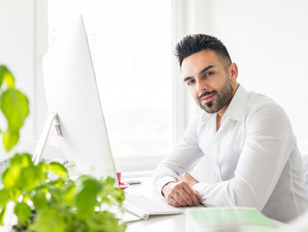 Young businessman working at office on computer desk