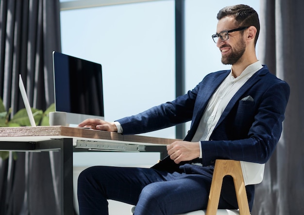 Young businessman working in office sitting at desk