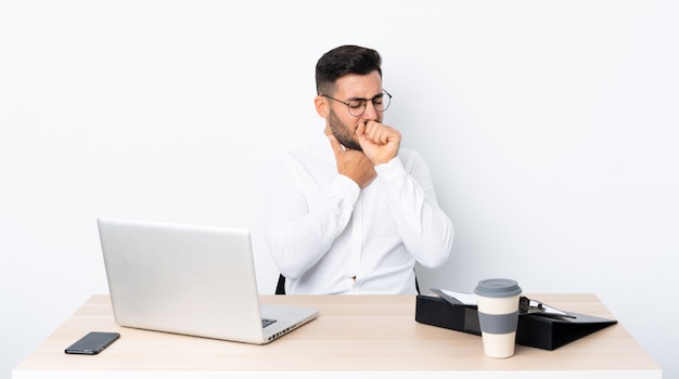 Young businessman in a workplace is suffering with cough and feeling bad