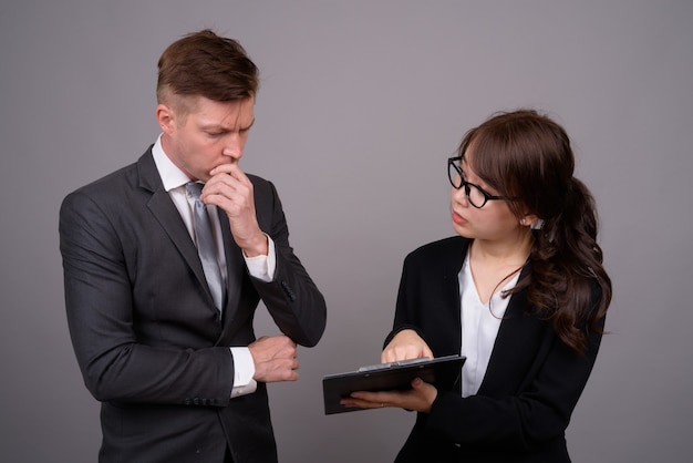 Young businessman and young Asian businesswoman together