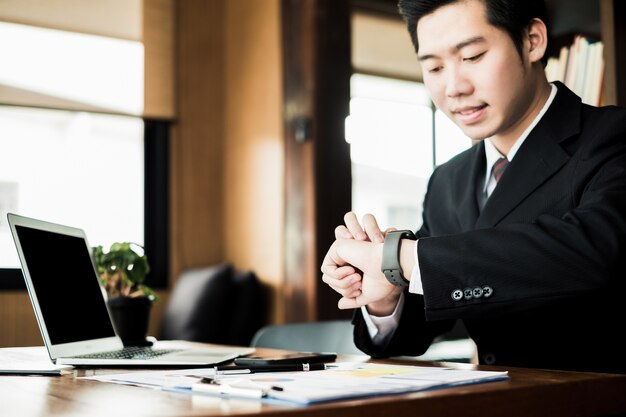 Young businessmen working in the office and watching the clock, business concept