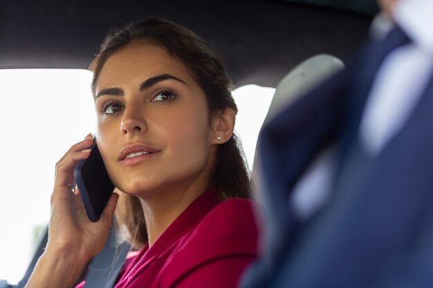 Young businesswoman. Beautiful young businesswoman calling secretary sitting near husband