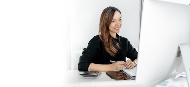 Young businesswoman in casual wear working on desktop computer at home office copy space