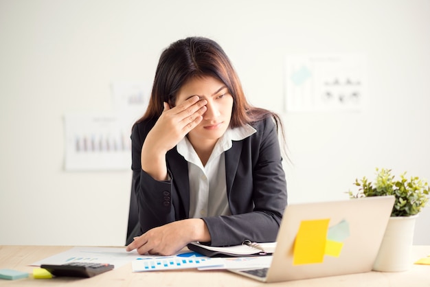 Young businesswoman doing exercises at workplace