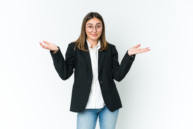 Young businesswoman doubting and shrugging shoulders in questioning gesture