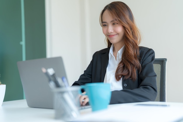 Young businesswoman drinking tea or coffee at her desk