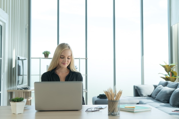 Young  businesswoman freelancer feeling happy with little smile while working at home office desk