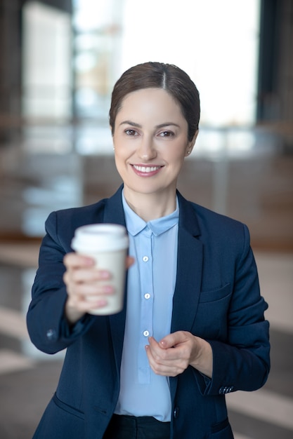 Young businesswoman in her uniform with a coffee