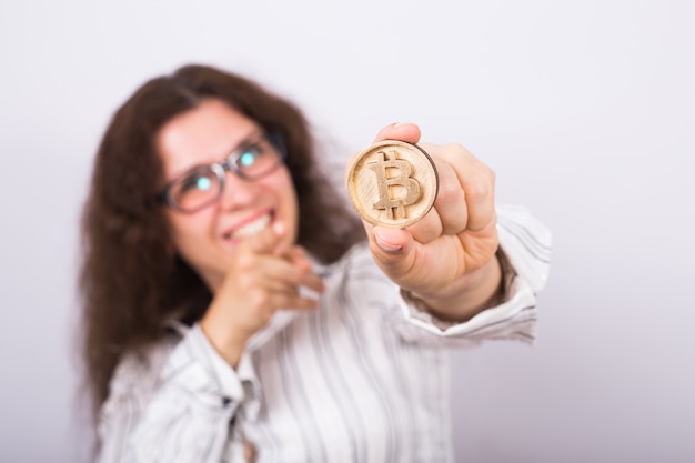 Young businesswoman holding a golden bitcoin