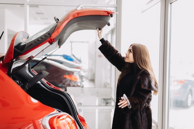 A young businesswoman is testing cars in a car store