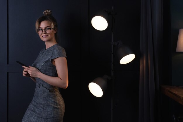 Young businesswoman is using smartphone  during late night work in office