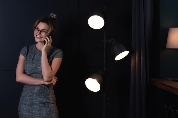 Young businesswoman is using smartphone  during late night work in office