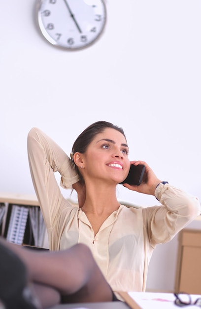 Young businesswoman sitting and talking on phone