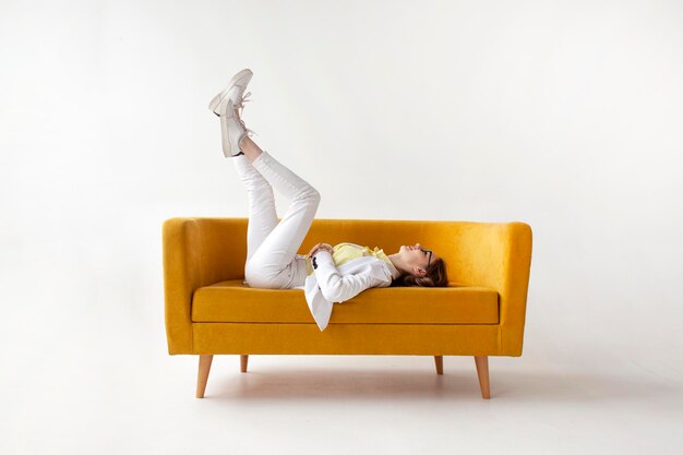 Photo young businesswoman in suit lies and rests on comfortable soft sofa girl in formal wear