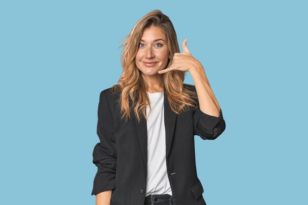 Photo young businesswoman in a suit showing a mobile phone call gesture with fingers