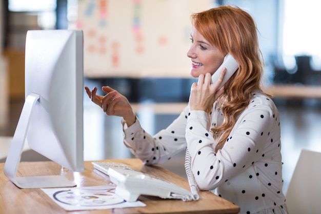 Young businesswoman talking on telephone