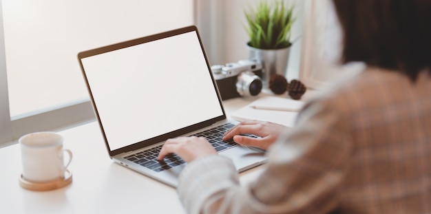 Young businesswoman typing on blank screen laptop computer