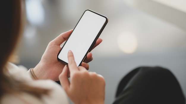 young businesswoman using blank screen smartphone in modern office