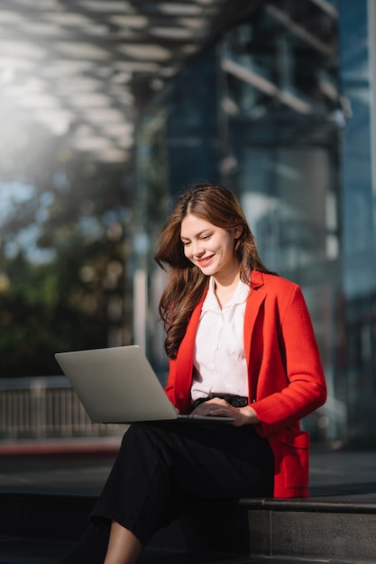 Young businesswoman using a Laptop tablet on a bench in the city