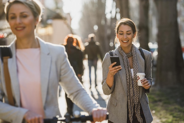 A young businesswoman using a smartphone while going to work.