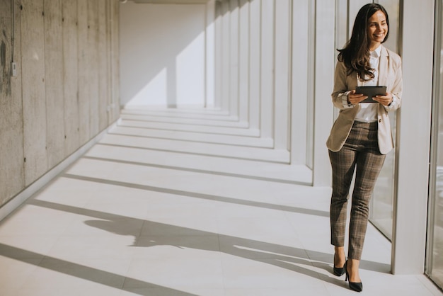 Young businesswoman walking on modern office hallway